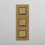 Six Position Triple Vertical Rocker Switch in Antique Brass Black on White Background