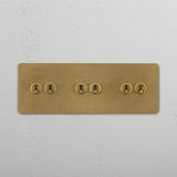 Antique Brass Triple Toggle Switch Designed with Six Levers on White Background